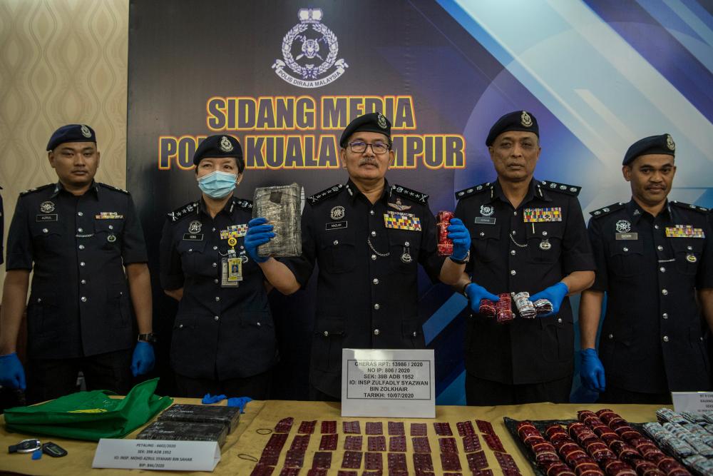 Kuala Lumpur police chief Datuk Seri Mazlan Lazim (C) displays the seized drugs at a press conference at the Kuala Lumpur contingent police headquarters today. - Bernama