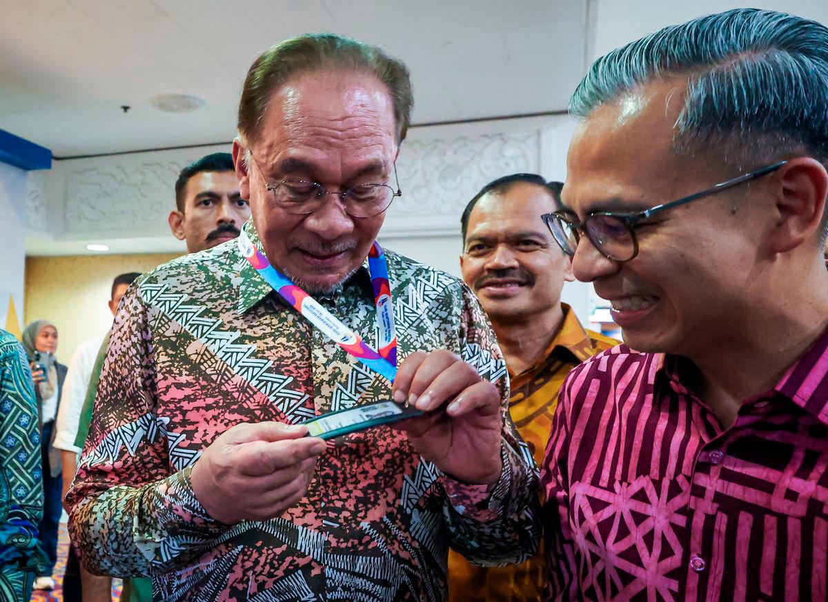 Perdana Menteri Datuk Seri Anwar Ibrahim melihat kad perakuan media pada Kemuncak Hari Wartawan Nasional 2025 di Dewan Merdeka Pusat Dagangan Dunia (WTC) hari ini. Turut sama Menteri Komunikasi Datuk Fahmi Fadzil. fotoBERNAMA