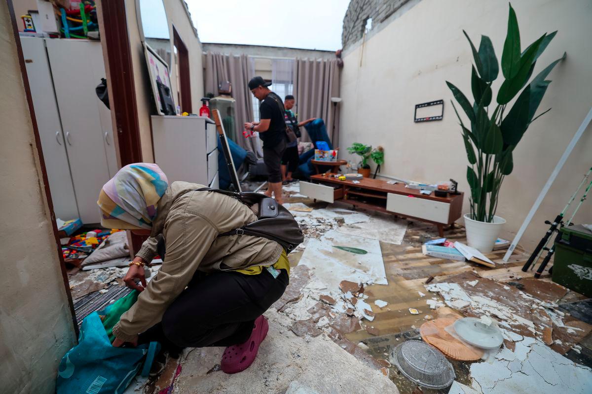 Mangsa Fazeela Yaccob bersama ahli keluarganya mengalihkan barangan yang rosak selepas bahagian bumbung rumahnya diterbangkan angin selepas kejadian ribut di PPR Seri Cempaka - fotoBERNAMA