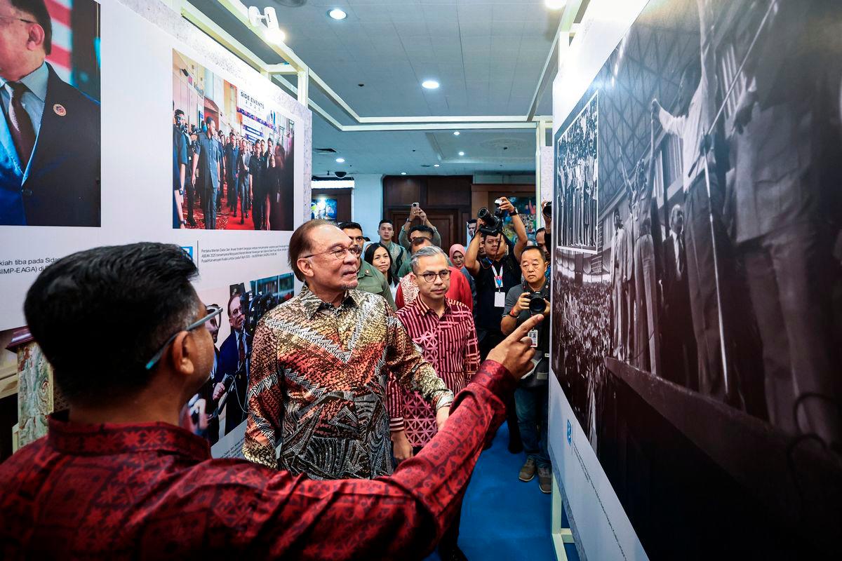 Perdana Menteri Datuk Seri Anwar Ibrahim (tengah) dan Menteri Komunikasi Datuk Fahmi Fadzil (kanan) mendengar penerangan dari Ketua Pengarang Bernama Arul Rajoo Durar Raj (kiri) ketika melawat pameran foto sempena sambutan Kemuncak Hari Wartawan Nasional 2025 di Dewan Merdeka Pusat Dagangan Dunia Kuala Lumpur (WTCKL) hari ini.- fotoBERNAMA