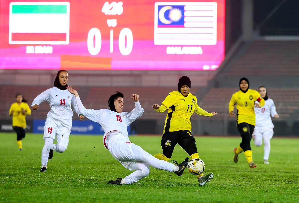 Pemain Malaysia Dian Aqilah Imran diasak pemain Iran Samaneh Ghamani pada perlawanan kumpulan F Kelayakan Piala Asia Wanita Bawah 20 di Stadium Bola Sepak Kuala Lumpur, semalam - BERNAMA