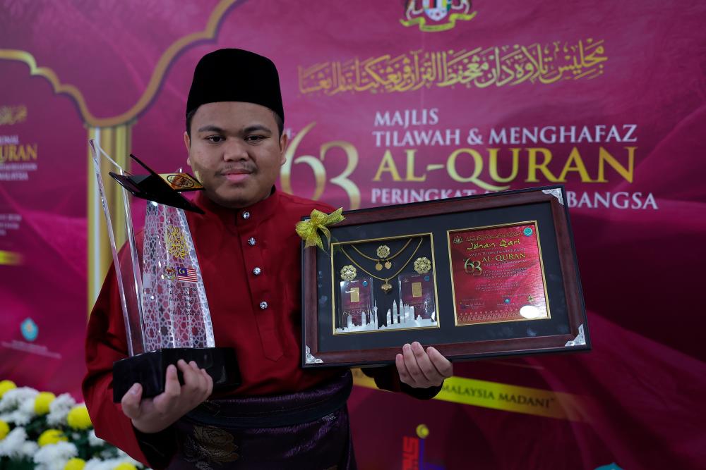 KUALA LUMPUR, 24 Ogos -- Johan Tilawah Al-Quran kategori lelaki Muhammad Qayyim Nizar Sarimi menunjuk piala yang dimenangi selepas Majlis Perasmian Penutupan Tilawah dan Menghafaz Al-Quran Peringkat Antarabangsa (MTHQA) ke-63 di Pusat Dagangan Dunia Kuala Lumpur (WTCKL) malam tadi. fotoBERNAMA