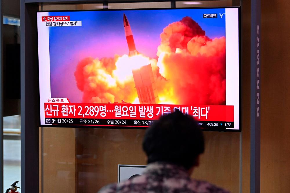 People watch a television news broadcast showing file footage of a North Korean missile test, at a railway station in Seoul on September 28, 2021, after North Korea fired an 'unidentified projectile' into the sea off its east coast according to the South's military. (Photo by Jung Yeon-je / AFP) -AFPPix
