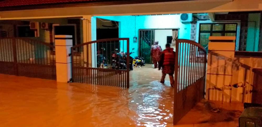 Officers from the Civil Defence Force at a house in Krubong following floods, on July 7, 2019. — Pix courtesy of Manja Adnan Sempit’s Facebook