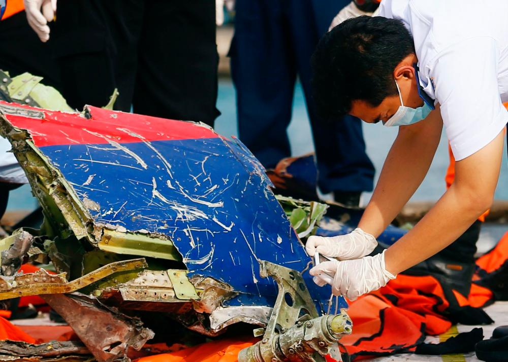 An officer of Indonesia’s National Transportation Safety Committee takes pictures of the remains of Sriwijaya Air flight SJ 182, which crashed into the Java Sea, on the last day of its search and rescue operation, at Tanjung Priok port in Jakarta, Indonesia, January 21, 2021. REUTERSPIX
