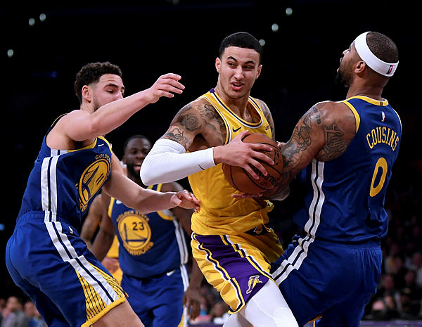 Kyle Kuzma #0 of the Los Angeles Lakers reacts to a DeMarcus Cousins #0 of the Golden State Warriors foul as he drives past Klay Thompson #11 during a 130-111 Warriors win at Staples Center. — AFP