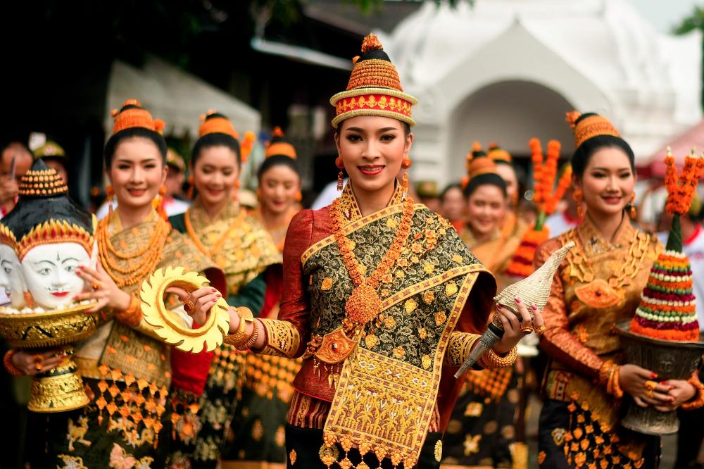 This photograph taken on April 15, 2019 shows Miss Laos New Year or Nang Sang Khan pageant winner Mila Douangximay (C) along with the other six chosen contestants, each symbolising King Kabinlaphom's seven daughters, taking part in the annual Laos New Year or Pi Mai celebrations at the Wat Xiengthong Buddhist temple in Luang Prabang. — AFP