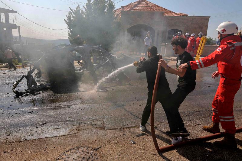 People douse the flames of a car hit by an Israeli strike in the southern Lebanese village of Burj al-Muluk on March 15, 2025, in which one person was reportedly killed.. AFPpix