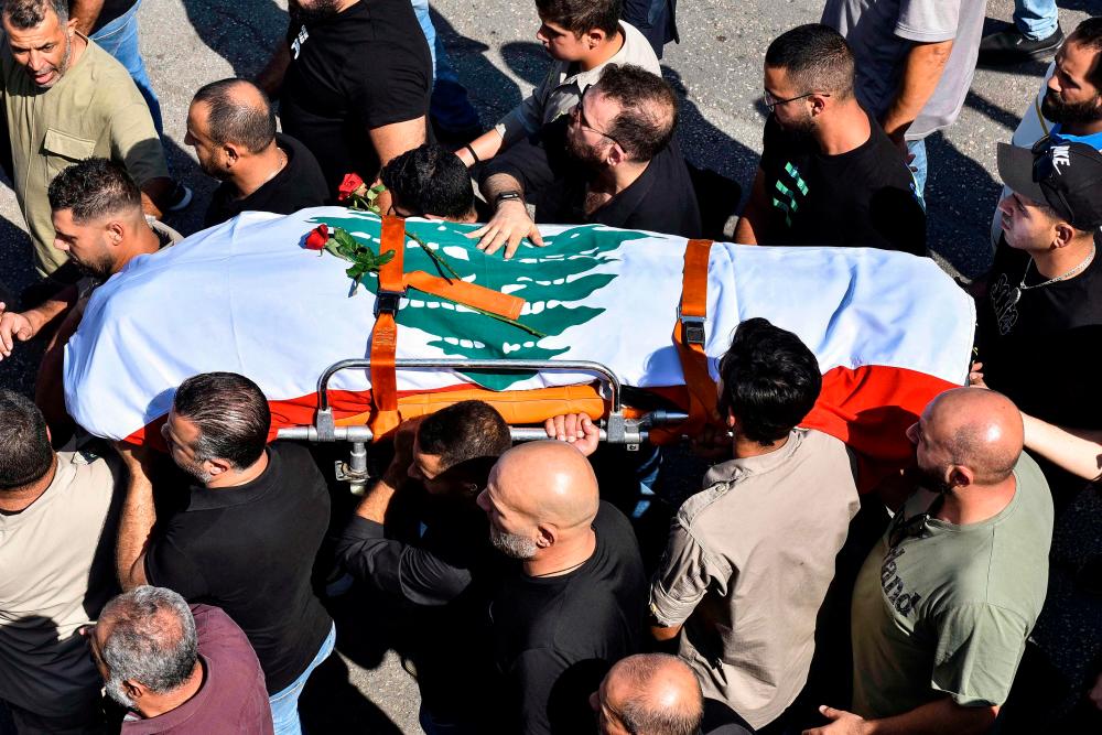 Mourners carry the casket of Lebanese Reuters video journalist Issam Abdallah, killed on October 13 by Israeli shelling at Alma al-Shaab border village with Israel while covering cross border shelling, during his funeral in the village of El-Khiam on October 14, 2023. AFPPIX