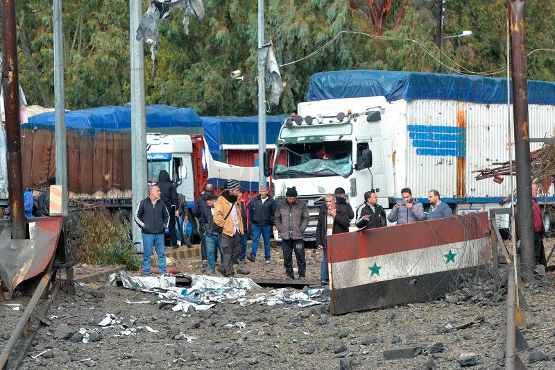 A picture taken from Lebanon shows Syrian officials inspecting the damage on the Syrian side of the Dabussiyeh border crossing after an Israeli airstrike on November 27, 2024. Syria’s defence ministry said six people were killed in Israeli strikes on border crossings with Lebanon just after midnight on November 27, hours before a Hezbollah-Israel ceasefire took effect. - Fathi AL-MASRI / AFP