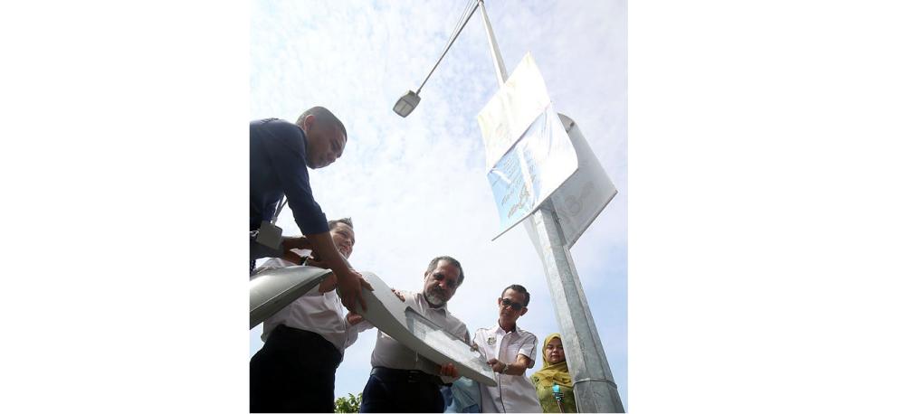 Penang Housing, Local Government, Town and Country Planning Committee chairman, Jagdeep Singh Deo (third, left) observing one of the LED street lights that will replace their predecessors.