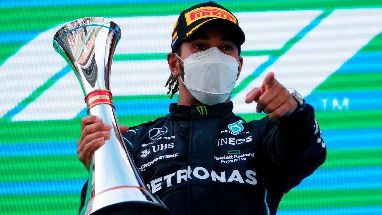 Mercedes’ F1 driver Lewis Hamilton celebrates winning the race on the podium with a trophy in the Spanish GP at the Circuit de Barcelona-Catalunya on May 9, 2021, – REUTERSPIX