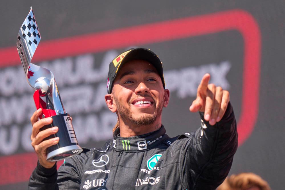 Mercedes' British driver Lewis Hamilton celebrates on the podium after placing third at the Canada Formula 1 Grand Prix on June 19, 2022, at Circuit Gilles-Villeneuve in Montreal. AFPpix
