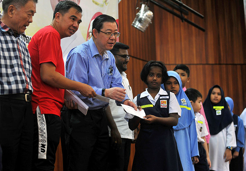 Finance Minister Lim Guan Eng hand out aid to primary and secondary students in the Bagan parliamentary constituency, on Jan 27, 2019. — Bernama