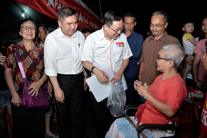 DAP secretary-general Lim Guan Eng and DAP National Organising Secretary Anthony Loke, greet wheelchair-bound Teo Chiu Choon, on the Rantau by-election campaign trail, on April 6, 2019. — Bernama