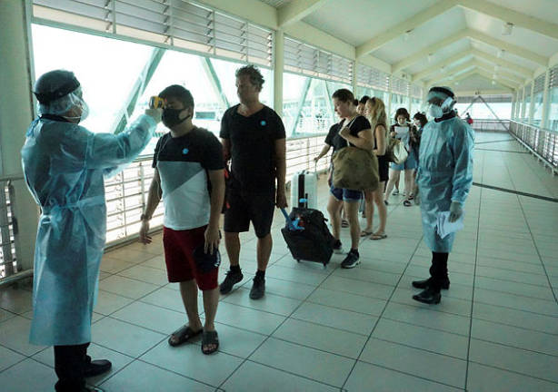 Health officials perform body temperature checks on tourists after they arrive from Thailand, at the Kuah Ferry Terminal, Langkawi, on Jan 26, 2020. — Bernama