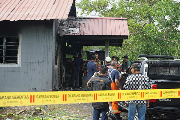 Firefighters and police personnel investigate the house fire that claimed three lives at Pangkalan Jeti Nelayan Sungai Tepi, near Bukit Malut, Langkawi on April 1, 2019. — Bernama