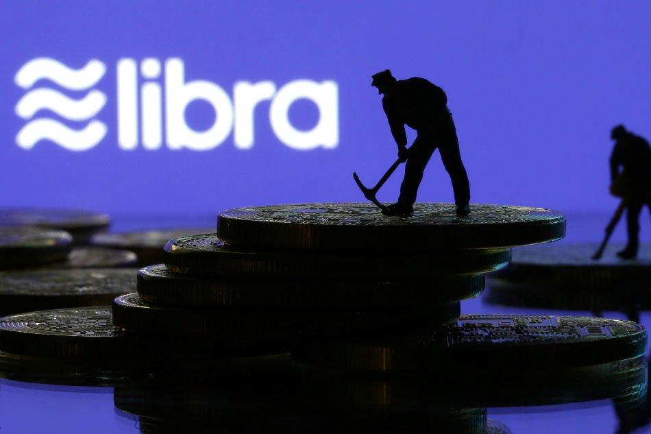 Small toy figures are seen on representations of virtual currency in front of the Libra logo in this illustration picture, June 21, 2019. — Reuters