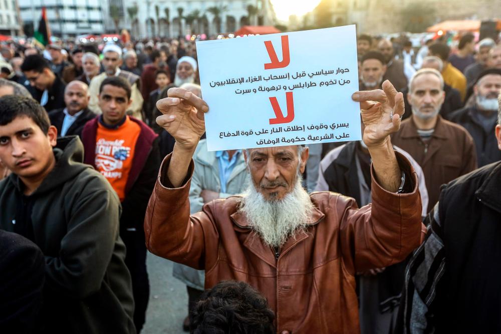 Demonstrator take part in a rally against eastern Libyan strongman Khalifa Haftar and in support of the UN-recognised government of national accord (GNA) in Martyrs' Square in the GNA-held capital Tripoli on January 10, 2020. - AFP