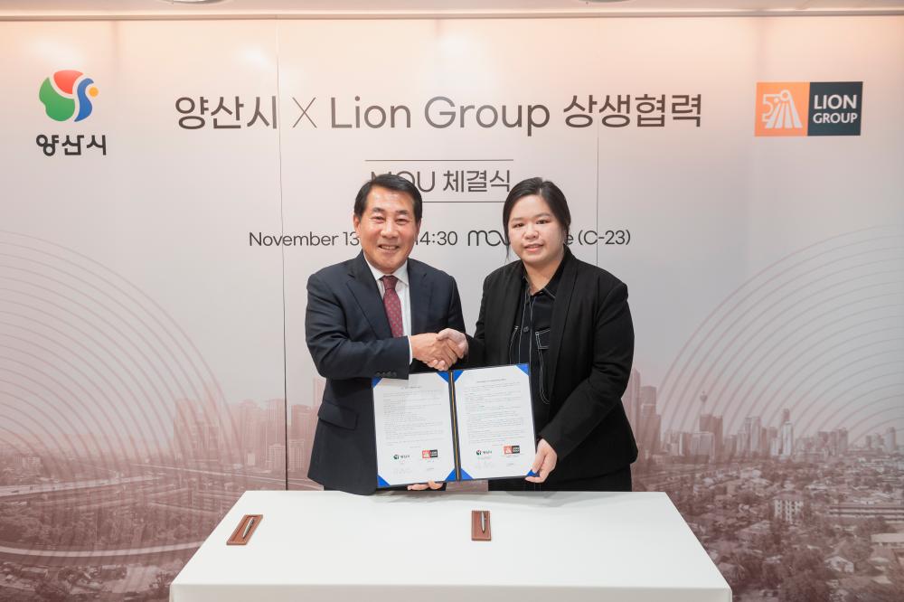Yangsan City mayor Na Dongyeon (left) and Cheng during the exchanging documents at the MoU ceremony.