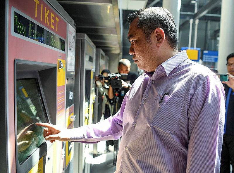 Transport Minister Anthony Loke uses one of the ticketing machines at the Kuala Lumpur KTM station, on Jan 6, 2019. — Bernama