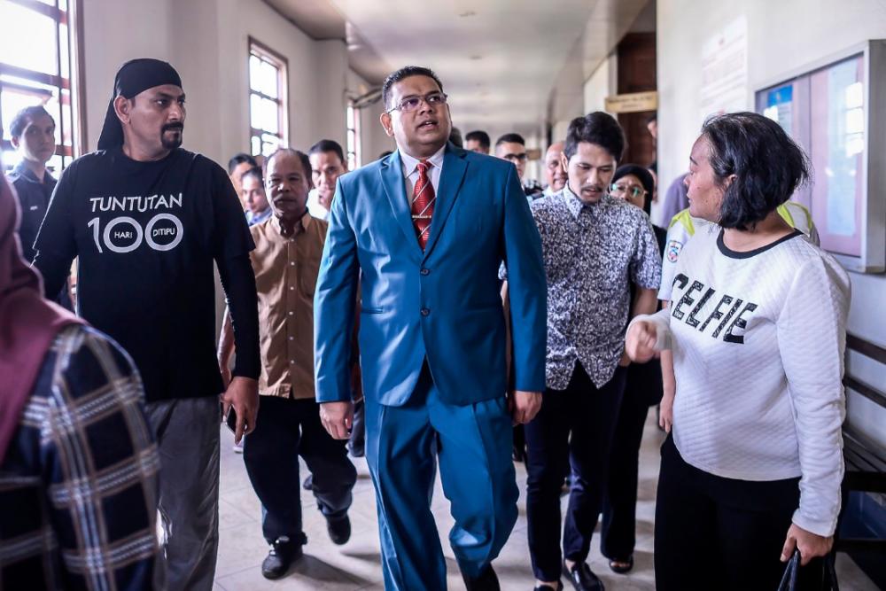 Umno supreme council member Datuk Lokman Noor Adam (C) arrives at the Jalan Duta sessions court, on March 28, 2019. — Sunpix by Adib Rawi Yahya