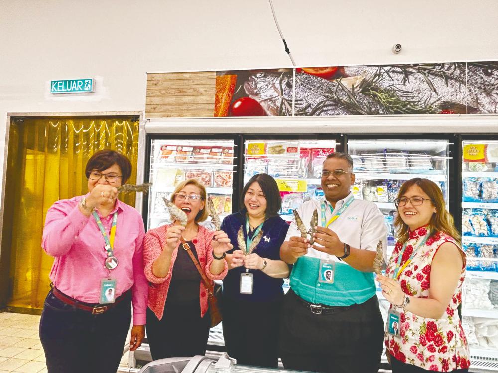 Yap (second from left), and May Li (middle), showcasing the XL tiger prawns, one of the key CNY SKUs that are being offered in Lotus’s Malaysia this CNY.