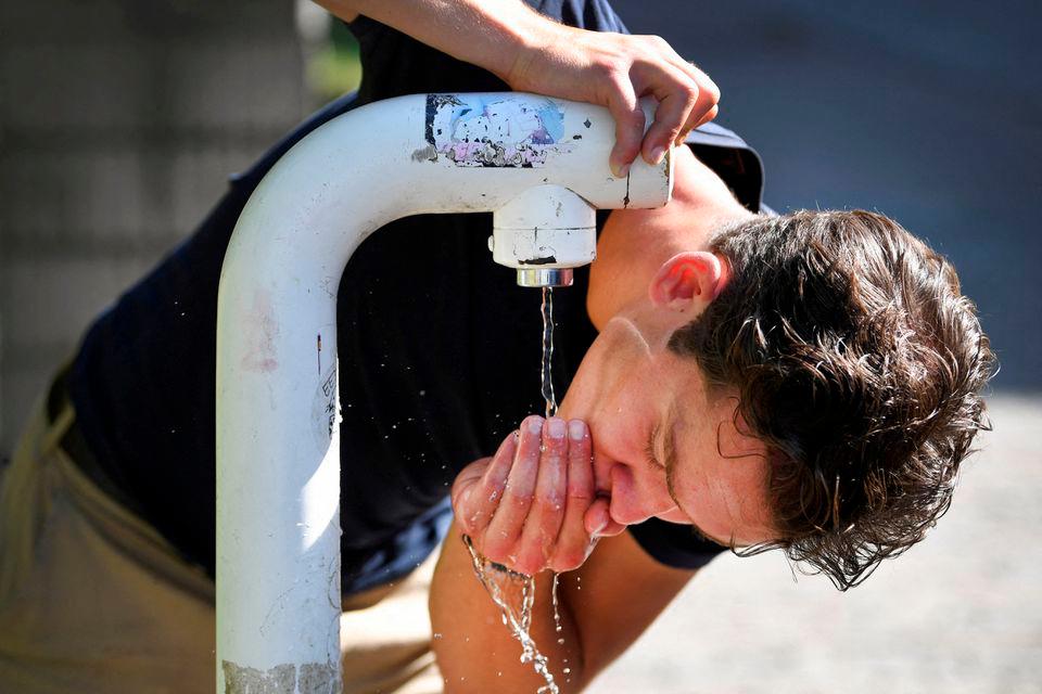 A man drinks water from a public drinking establishment during a heatwave in Nijmegen, Netherlands July 18, 2022. REUTERSPIX
