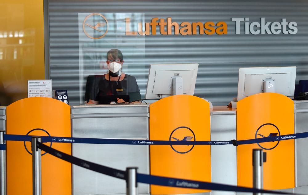 An employee of Lufthansa sitting at the ticket desk in an empty terminal of the company at the Franz-Josef-Strauss Airport in Munich, Germany. At the height of the virus crisis, daily passengers dwindled to 3,000 from the usual 350,000.– AFP