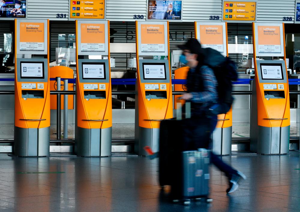 A passenger walking past a Lufthansa ticket counter at Frankfurt Airport, Germany, on Monday. REUTERSPIX