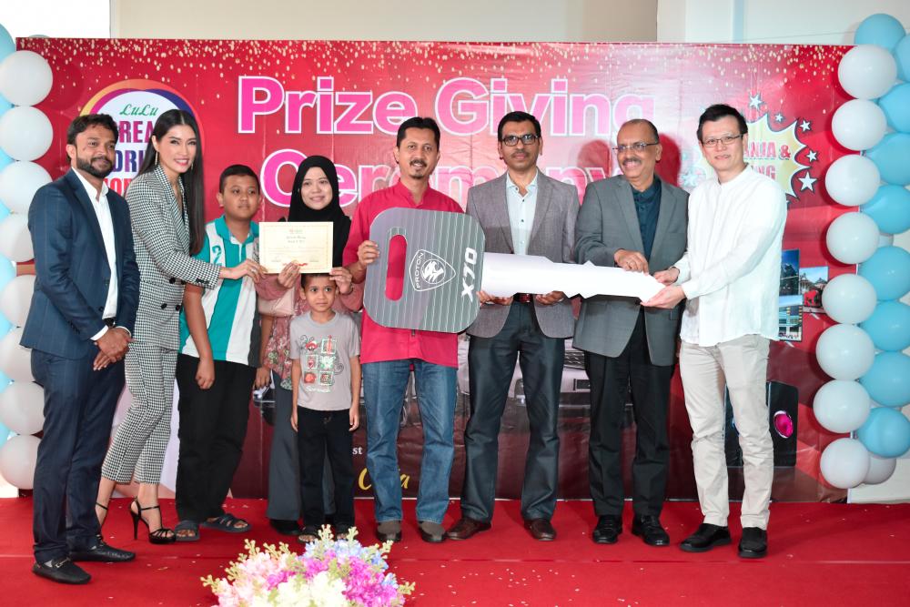 From left: Lulu’s regional manager Shihab N Yousaf, Amber Chia, Roslee (in a red shirt) with his family, Lulu’s regional director Asif Moidu, Tan Sri Ali Hamsa and 1 Shamelin Mall general manager Jimmy Ho.