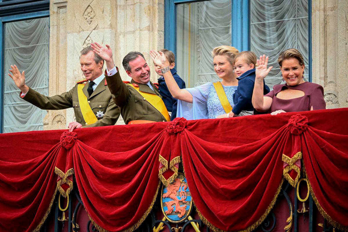 Luxembourg’s Grand Duke Guillaume (2nd L) and Duchess Stephanie (3rd R) hold their sons Charles (3rd L) and Francois (2nd R) as they wave with Grand Duke Henri (L) and Duchess Maria Teresa (R) from the balcony of the Grand Ducal Palace after being sworn-in as Grand Duke Head of State and Duchess of Luxembourg in Luxembourg city on October 3, 2025. (Photo by NICOLAS TUCAT / AFP)