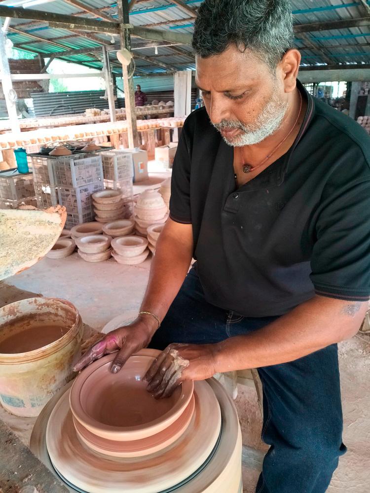 Master craftsman Reguraj making pottery on the wheel. $!Master craftsman Reguraj making pottery on the wheel.