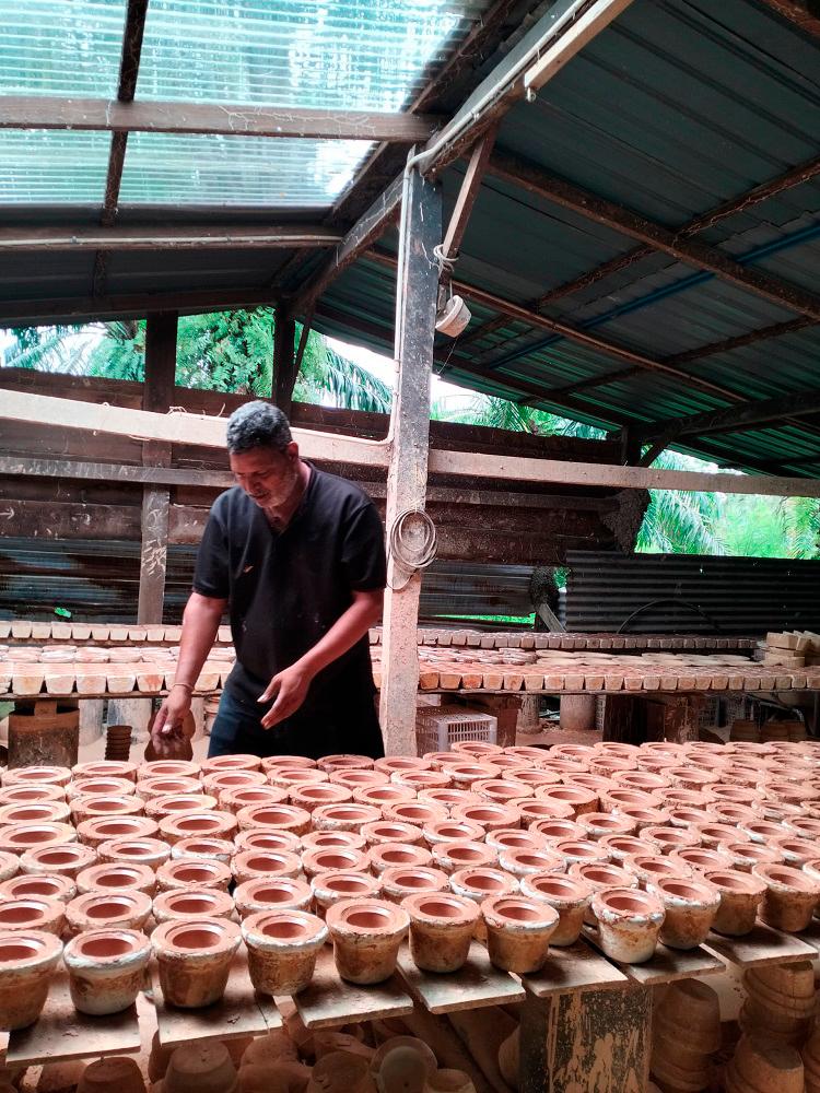Reguraj checking the quality of the claypots.