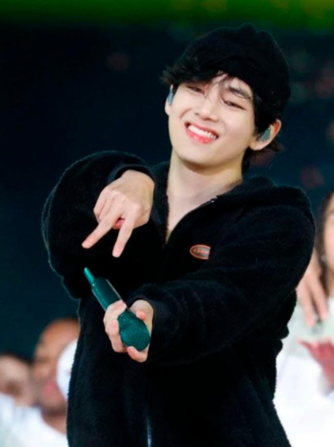Taehyung showing the sign for ‘dance’ during a concert. – Allkpop