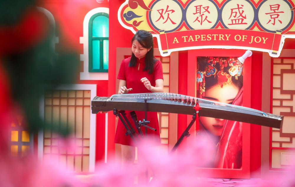 Sim playing the guzheng at the 3 Damansara mall. – ALL PICS BY AMIRUL SYAFIQ/THE SUN