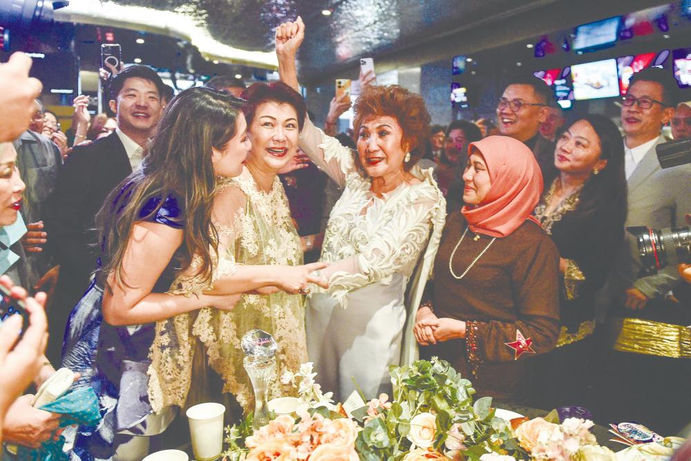 Datin Janet Yeoh (third from left) celebrating with well-wishers after daughter Michelle’s win. – AFP