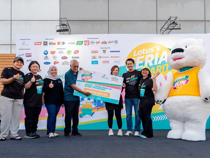 $!Saksit (second from right) handing over the mock cheque of the fundraised RM400,000 towards Pintar Foundation Board of Trustees chairman Tun Zaki Azmi (fourth from left) and Pintar Foundation general manager Norzalina Masom (third from left), accompanied by Lotus’s executive committee members.