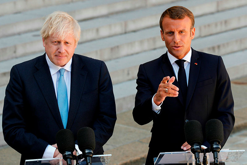 French President Emmanuel Macron (R) gestures as he delivers a speech to the press next to Britain’s Prime Minister Boris Johnson (L) prior to their meeting at The Elysee Palace in Paris on Aug 22, 2019. — AFP