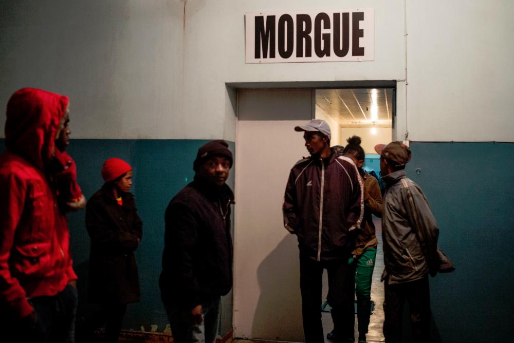 People walk out of the morgue at Joseph Ravoahangy Andrianavalona Hospital (HJRA) in Antananarivo late on June 26, 2019, after at least 16 people died and dozens were injured during independence day celebrations. — AFP