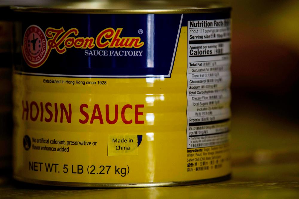 A printed label which reads ‘Made in China’ is used to cover ‘Made in Hong Kong’ labelling on a tin of sauce produced at the Koon Chun Sauce Factory in Hong Kong. – AFPPIX