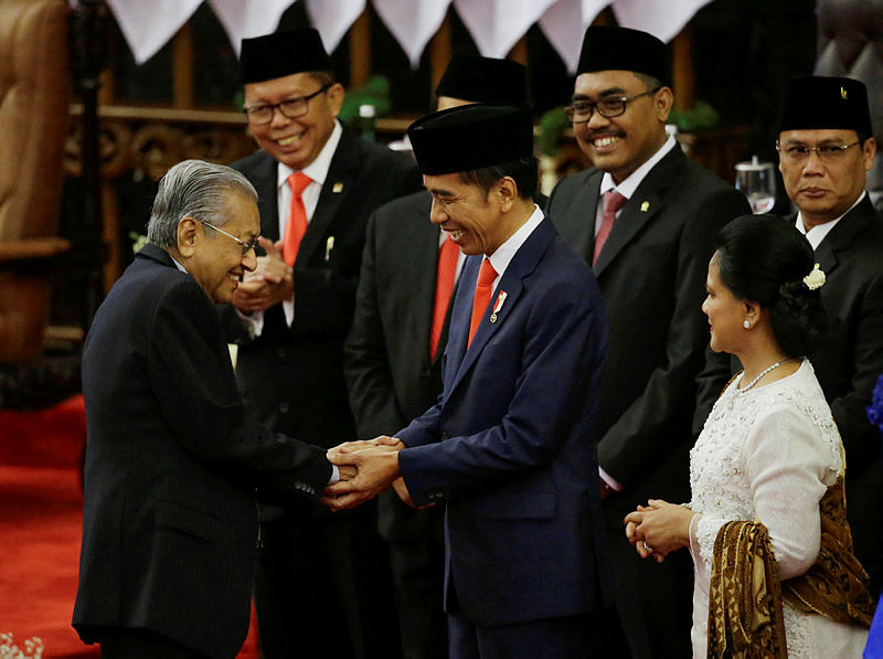Indonesian President Joko Widodo shakes hands with Prime Minister Mahathir Mohamad after his presidential inauguration for the second term, at the House of Representatives building in Jakarta, Indonesia, Oct 20, 2019. — Reuters
