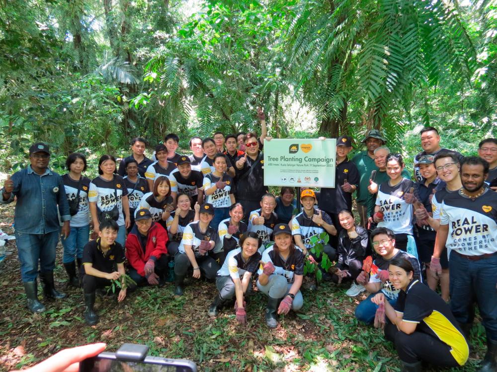 Upatkoon (in orange cap) with company executive vice-presidents and personnel during the sapling planting.