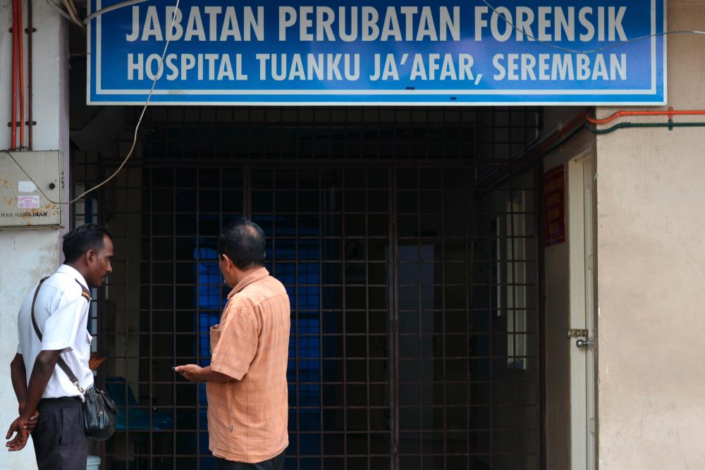 People talk outside the forensic department of the Tuanku Ja'afar Hospital in Seremban on August 14, 2019, after the body of missing 15-year-old Franco-Irish teenager Nora Quoirin was found. - AFP