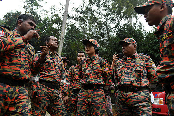 Members of a rescue team take part in a briefing before continuing search efforts to locate missing 15-year-old Franco-Irish teenager Nora Anne in Seremban on Aug 10. — AFP