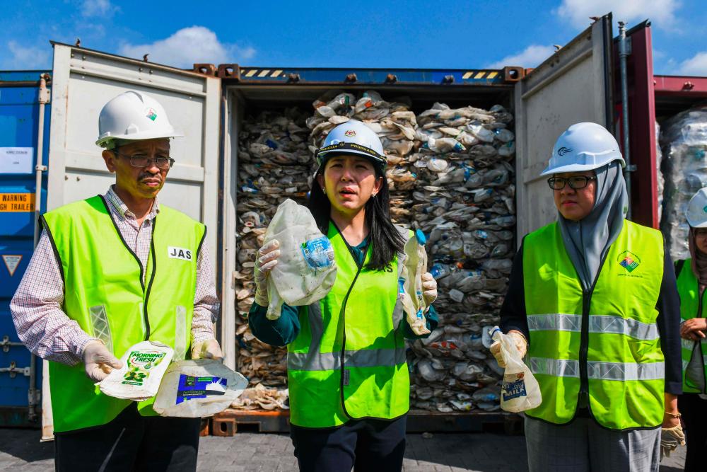 Minister of Energy, Science, Technology, Environment and Climate Change, Yeo Bee Yin (C) shows samples of a plastics waste shipment from Australia before sending it back to the country of origin in Port Klang, on May 28, 2019. - AFP
