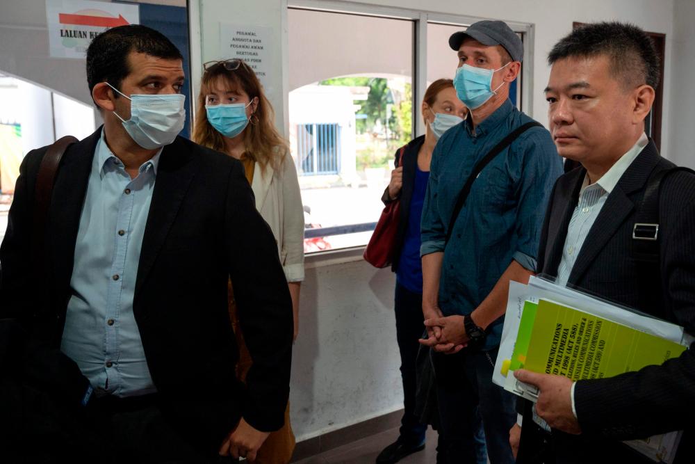 Australian Al Jazeera journalists, reporter/senior producer Drew Ambrose (L), executive producer Sharon Roobol (3rd R) and cameraman Craig Hansen (2nd R), involved in a documentary about the arrests of undocumented migrants arrive at the Bukit Aman police headquarters in Kuala Lumpur on July 10, 2020. — AFP