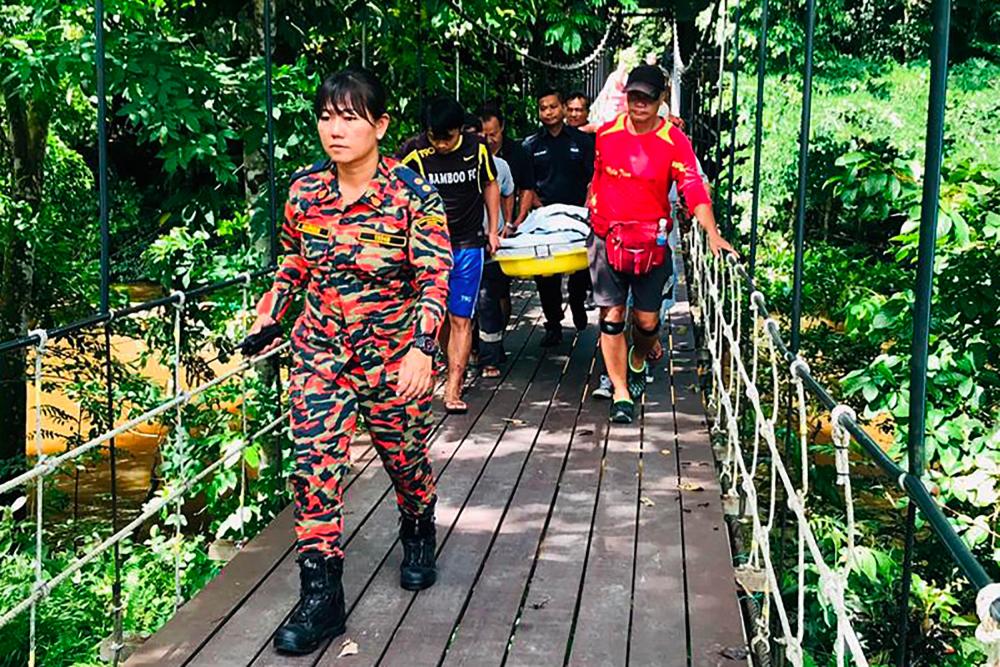 This handout from the Sarawak Fire and Rescue Department taken and released on July 13, 2019 shows the body of Dutch tourist Peter Hans Hovenkamp being carried out of Mulu National Park on the island of Borneo. - AFP
