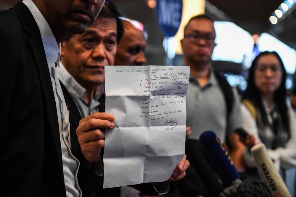 Vietnamese national Doan Thi Huong's lawyer Hisyam Teh Poh Teik (2nd L) shows a letter at KLIA on May 3, 2019, followwing her release from prison after charges that she was involved in the murder of Kim Jong Nam, the half-brother of North Korean leader Kim Jong Un, were withdrawn. - AFP