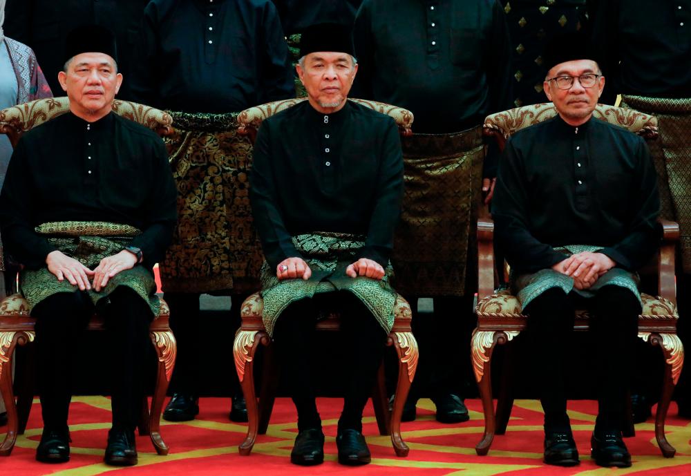 Prime Minister Anwar Ibrahim (R) poses with Deputy Prime Ministers Datuk Seri Ahmad Zahid Hamidi (C) and Datuk Seri Fadillah Yusof (L) after the swearing-in ceremony of the newly appointed cabinet ministers at the Istana Negara in Kuala Lumpur, on December 3, 2022. AFPPIX